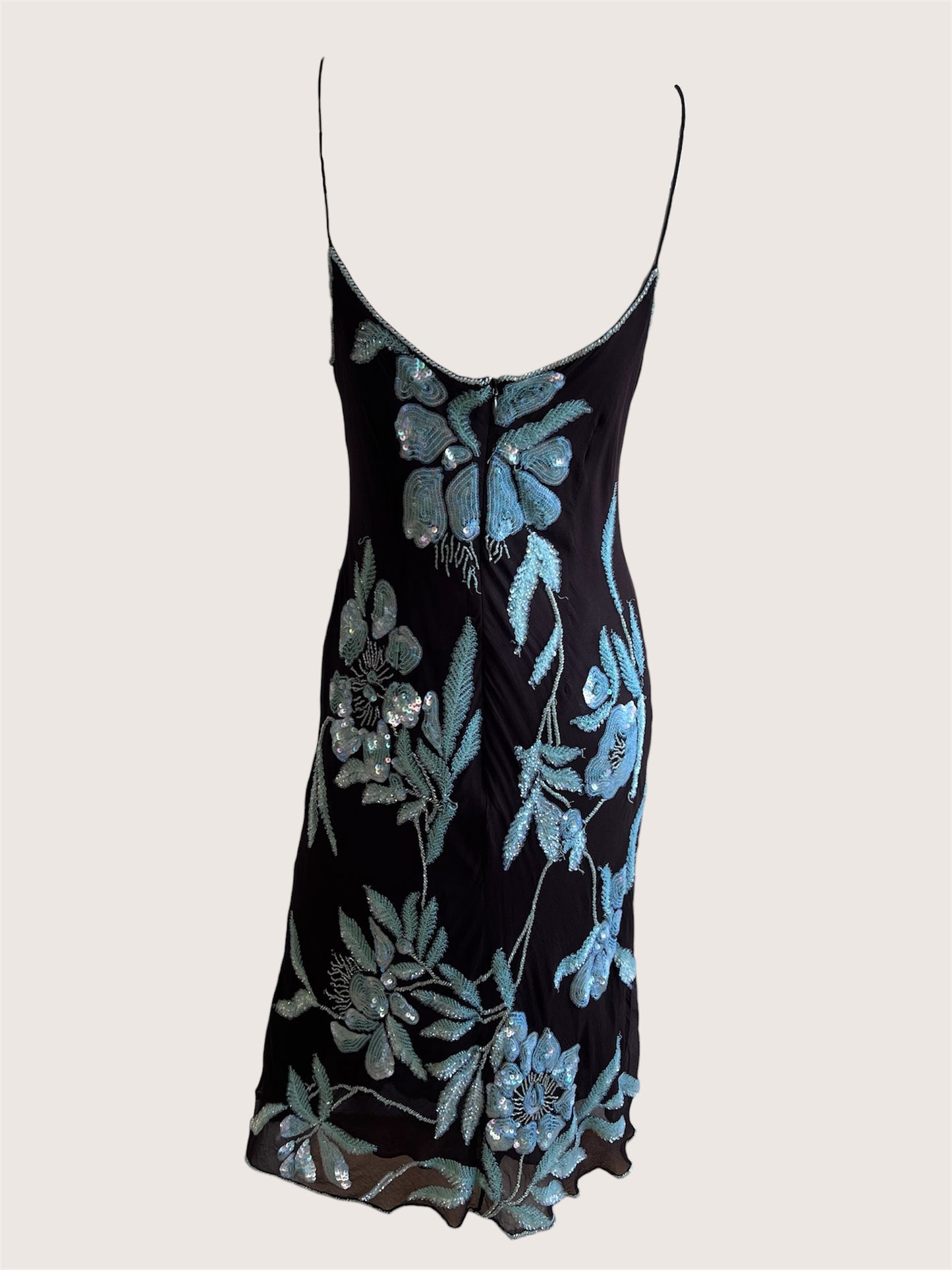 Black slip dress with blue floral embroidery on a white background