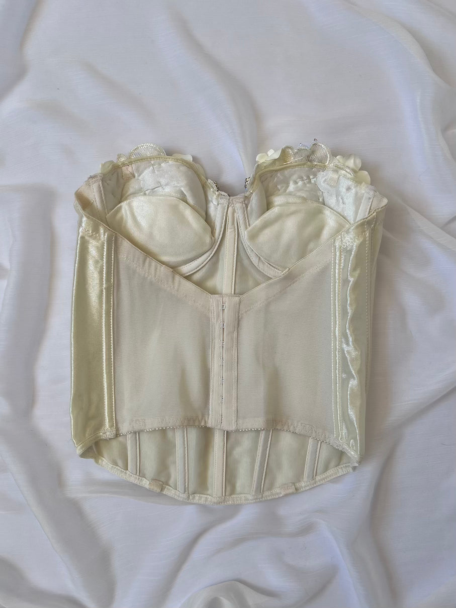 Vintage-style cream-colored corset on a white fabric background