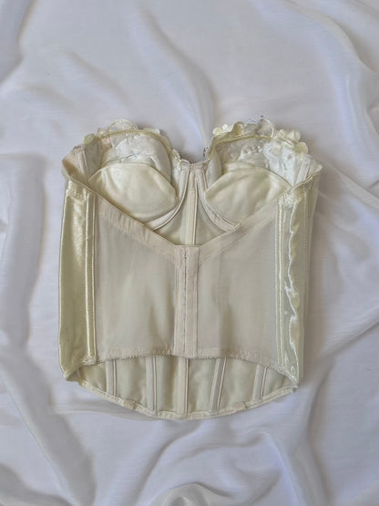 Vintage-style cream-colored corset on a white fabric background