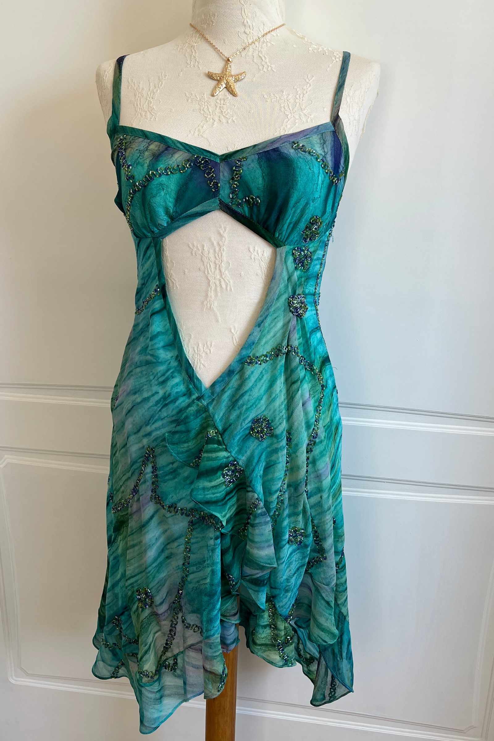 Vintage teal beaded mini dress with open back and ruffled hem, side view
